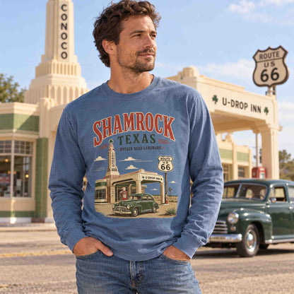 Man wearing a Blue Jean Shamrock Texas Route 66 long sleeve graphic tee in front of the U-Drop Inn and a classic green car.