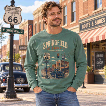 Man wearing a Light Green Springfield Missouri Route 66 long sleeve graphic tee on a vintage-style main street.