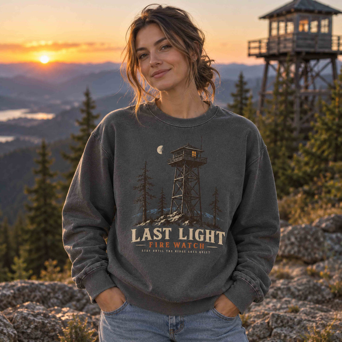 Pepper Last Light Fire Watch graphic sweatshirt worn near a fire lookout tower at sunset