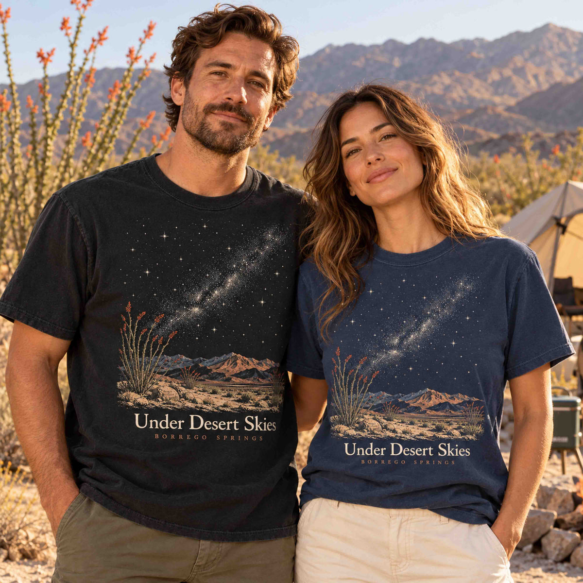 Man and woman wearing Being is Good Under Desert Skies Borrego Springs T-shirts in Black and Navy in a desert campsite setting.