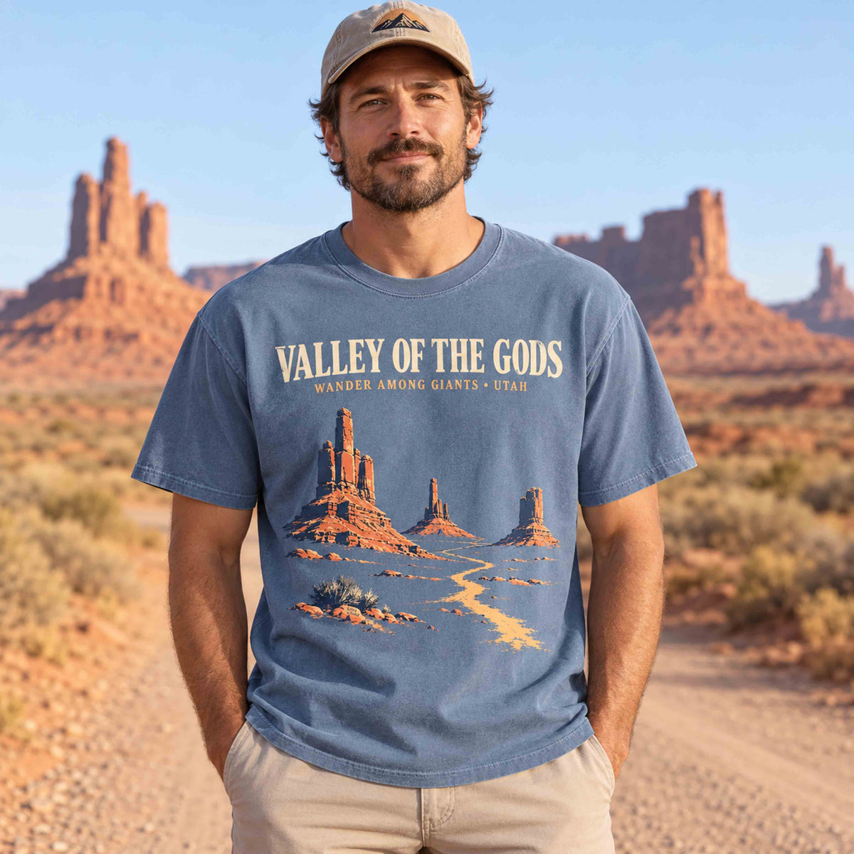 Man wearing a Blue Jean Valley of the Gods Utah graphic T-shirt with sandstone towers and a winding desert road design.