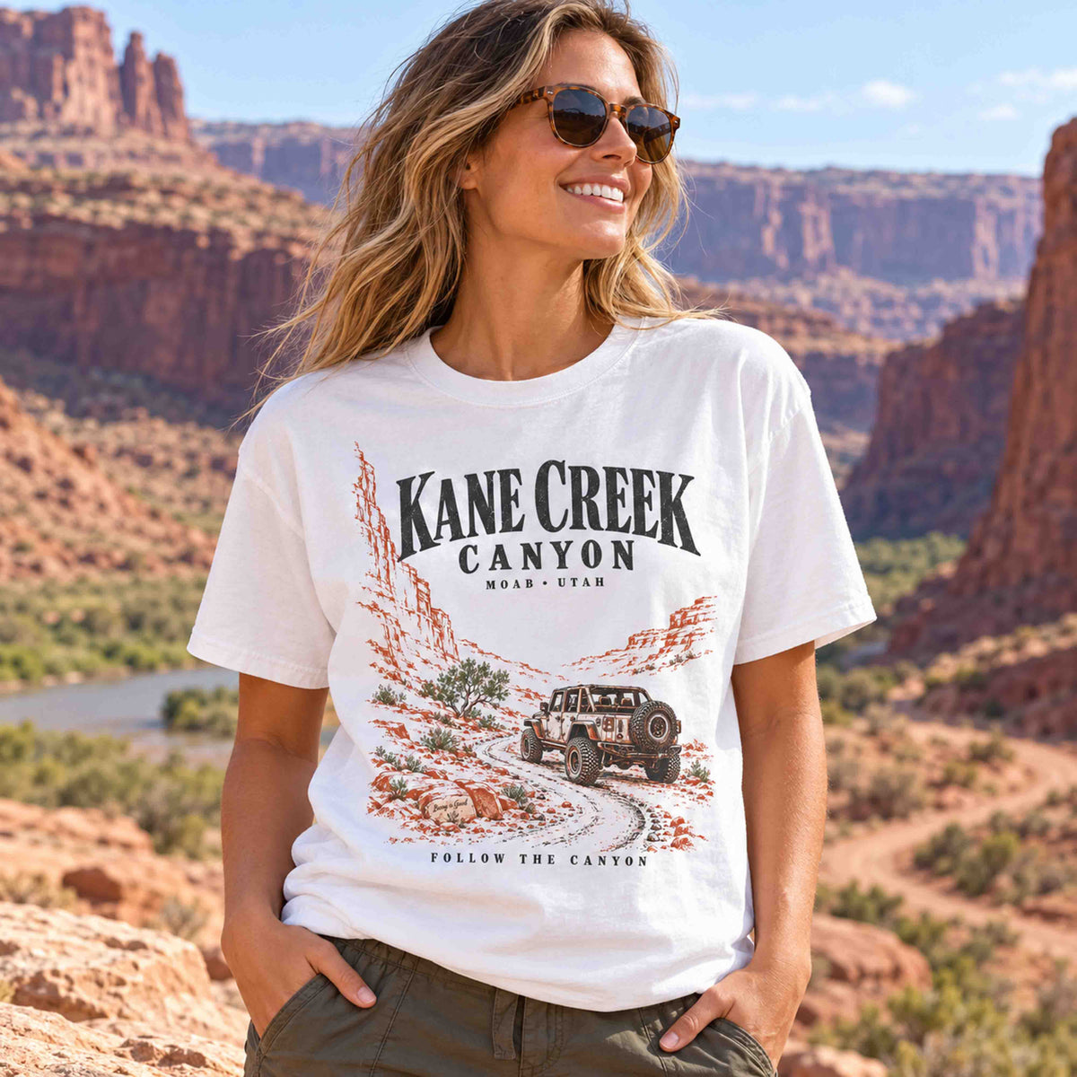 Woman wearing the White Kane Creek Canyon off-road graphic tee in a desert canyon.