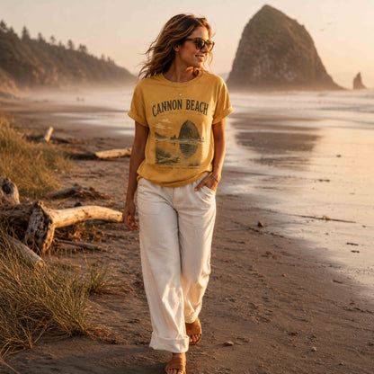 Woman wearing Cannon Beach Oregon Coast graphic t-shirt in Mustard near Haystack Rock