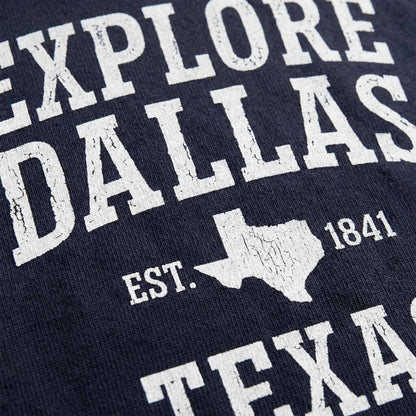 Close-up of vintage distressed Explore Dallas typography graphic on navy t-shirt
