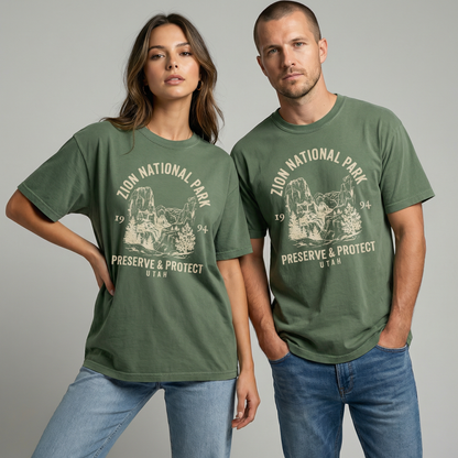 Moss green Zion National Park graphic t-shirt on wooden hanger with soft cream canyon landscape artwork