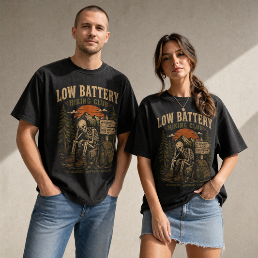 Low Battery Hiking Club skeleton hiking graphic tee on black shirt with vintage mountain and outdoor trail artwork