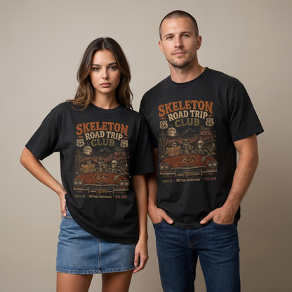 Unisex black Route 66 graphic tee featuring Skeleton Road Trip Club artwork with skeletons in a vintage car, haunted motel, desert cactus, moon, and 1926–2026 anniversary text.