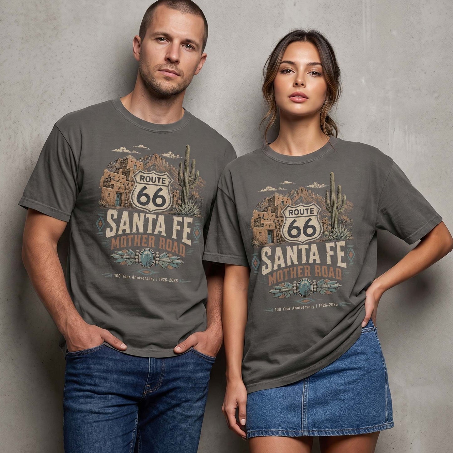 Models wearing Santa Fe Mother Road Route 66 graphic t-shirts with vintage southwestern desert artwork, adobe buildings, cactus, and turquoise details.