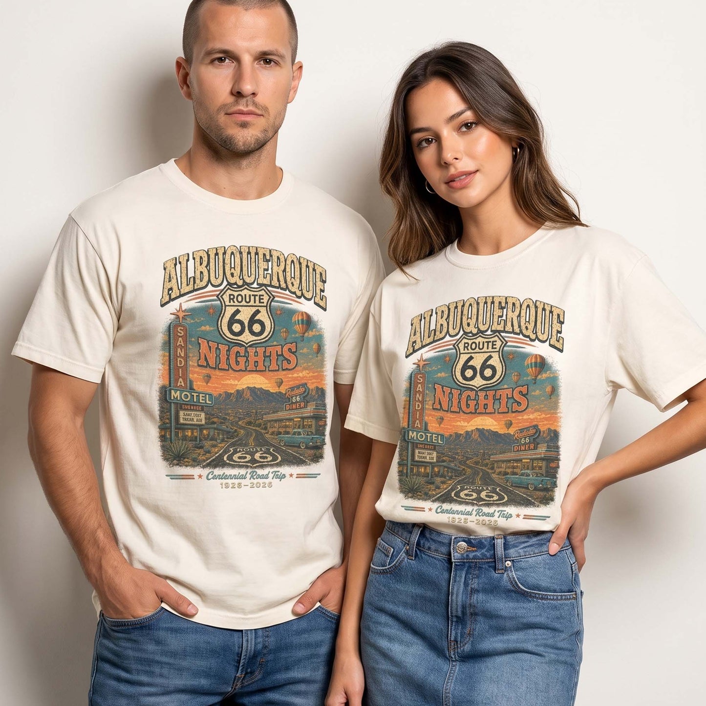 Unisex Albuquerque Route 66 graphic tee featuring desert highway artwork, motel sign, hot air balloons, mountains, classic car, and 1926–2026 centennial road trip text.
