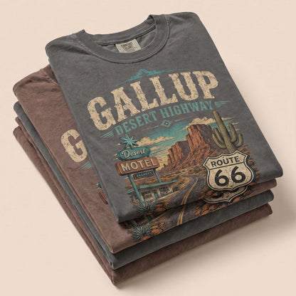 Unisex Gallup New Mexico Route 66 graphic tee featuring desert highway artwork, motel sign, canyon scenery, cactus details, Route 66 shield, and vintage Southwest travel style.