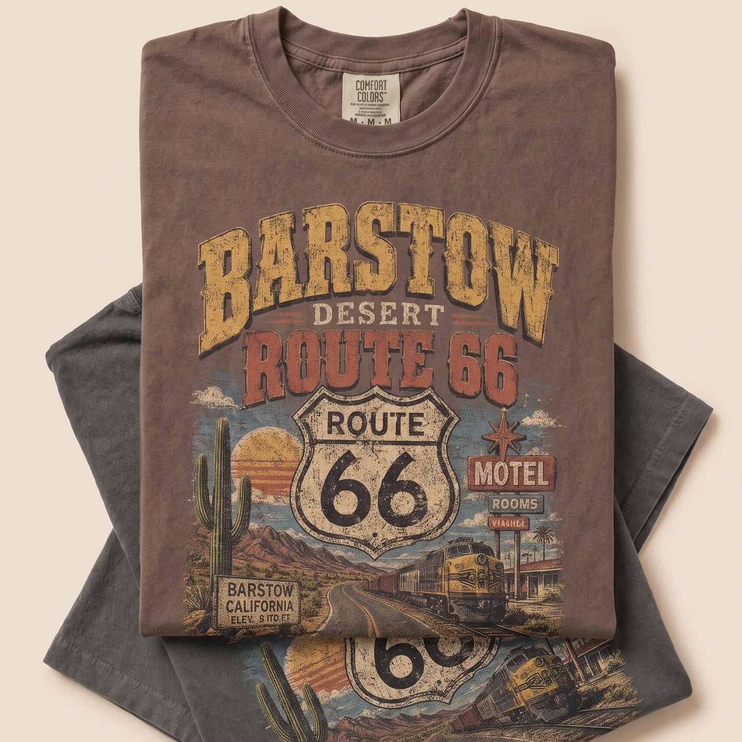 Unisex Barstow California Route 66 graphic tee featuring desert highway artwork, Route 66 shield, cactus details, vintage motel sign, roadside scenery, and 1926–2026 anniversary text.